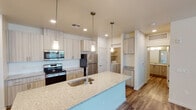 Located along North Valley Pkwy in Phoenix, AZ 85085, this single-story residence offers a thoughtfully designed open-concept layout with contemporary finishes throughout. The kitchen serves as the centerpiece of the living area, showcasing light wood-tone cabinetry extending to the ceiling, a granite-topped island with an undermount sink, stainless steel appliances including an electric range, built-in microwave, and refrigerator, and elegant pendant lighting overhead. Wood-style plank flooring flows seamlessly through the main living and kitchen areas, adding warmth and visual continuity. The open living area is bright and airy, featuring recessed lighting and a sliding glass door that opens to an outdoor space, allowing natural light to fill the room. A ceiling fan adds comfort to both the living area and the bedrooms. The bedrooms are carpeted for comfort and feature high-set windows that allow light in while maintaining privacy. The bathroom is clean and functional, featuring a combined shower and tub, a granite-topped vanity with wood-tone cabinetry, and wood-style flooring. A dedicated in-unit laundry area adds everyday convenience. The overall aesthetic is clean and modern, with a neutral palette that creates a bright, welcoming atmosphere throughout.