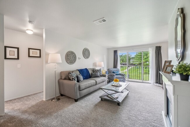 Elevated living room and private patio or balcony at Drawbridge Apartments in Harrison Township, MI. - Drawbridge Apartments East