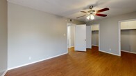 Located at 2414 Ventura Dr in Austin, TX, this one-bedroom, two-bathroom residence offers a thoughtfully organized single-floor layout that maximizes every square foot. Warm hardwood-style flooring runs throughout the home, lending a cohesive and inviting feel from room to room.

The bedroom is generously sized, featuring a ceiling fan with light fixture, a textured ceiling, and a window that allows natural light to brighten the space. A dedicated closet provides practical storage directly off the room.

The galley-style kitchen is efficiently arranged with cabinetry lining both sides, a stainless steel refrigerator, a dishwasher, a double sink, and light countertops that contrast the darker cabinet finish. The layout keeps everything within easy reach.

A central hallway connects the main living areas and leads to both bathrooms. One bathroom features a full tub-shower combination with white tile surround and chrome fixtures. Two closets throughout the unit offer additional storage flexibility.

The living area is open and airy, with a ceiling fan overhead and clear sightlines to the kitchen and hallway. Neutral gray walls throughout keep the interior feeling clean and adaptable. The textured ceilings add a subtle traditional character to the overall design.
