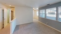 This single-floor, 2-bedroom, 2-bathroom residence offers a clean, well-organized layout designed for comfortable everyday living. The kitchen is outfitted with white cabinetry providing generous storage, light-toned countertops, a stainless steel sink, recessed lighting, and white appliances including a refrigerator, electric range, microwave, and dishwasher. A dedicated pantry closet off the kitchen adds further storage convenience. The kitchen transitions seamlessly into the main living area, which features plush carpeting, a ceiling fan, and windows that invite natural light. Both bedrooms are carpeted and equipped with ceiling fans and windows overlooking the surroundings. The primary bedroom includes a spacious closet with built-in rods, offering ample storage. The two bathrooms mirror each other in their clean, bright aesthetic, each featuring wood-look flooring, a white vanity with a light stone-style countertop, a large mirror, and a toilet. One bathroom includes a walk-in shower with sliding glass doors, while the second features a full soaking tub and shower combination with a window for natural light. The entry area features tile flooring and access to multiple interior doors, providing a practical and organized flow throughout the unit.
