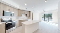 Located at 425 Centerpointe Circle in Altamonte Springs, FL, this thoughtfully designed 2-bedroom, 2-bathroom residence offers a bright, modern living experience across a single floor. The open-concept layout seamlessly connects the kitchen, dining, and living areas, creating a spacious and airy atmosphere. The contemporary kitchen is a standout feature, showcasing light wood cabinetry, a subway tile backsplash, white quartz countertops, stainless steel appliances including a refrigerator, range, and microwave, and a curved center island that doubles as additional prep and dining space. Light wood-style flooring flows throughout the main living areas, complementing the neutral color palette. The living area benefits from sliding glass doors that invite natural light and outdoor views. Both bedrooms are well-proportioned, each featuring ceiling fans, large windows with outdoor views, and light-filled interiors. The two bathrooms are finished with elegant marble-style tile flooring. One bathroom includes a glass-enclosed walk-in shower, while the other features a soaking tub and shower combination. Additional highlights include a dedicated laundry area, a utility room, two closets, and recessed lighting throughout.
