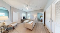 This thoughtfully laid-out 2-bedroom, 2-bathroom residence offers a comfortable and cohesive living experience across a single floor. The open-concept living room serves as the heart of the home, featuring light wood-style flooring, a ceiling fan, and multiple windows dressed with horizontal blinds that invite ample natural light. The space accommodates a relaxed seating arrangement with easy access to the adjacent bedrooms.

The kitchen is well-appointed with gray cabinetry, granite-style countertops, a white subway tile backsplash, and a full suite of stainless steel appliances including a range, microwave, and refrigerator. Light wood flooring continues throughout, giving the kitchen a clean, modern feel.

The primary bedroom is a generously sized retreat with plush carpet, dual windows, and a closet, offering a calm and private atmosphere. The second bedroom, also carpeted, provides a cozy and functional space suitable for guests or a home office.

Both bathrooms are finished consistently with granite-topped vanities, light wood flooring, and full tub-shower combinations with built-in shelving. The primary bath additionally features open shelving for added storage. A hallway connects the main living areas to the bedrooms and bathrooms, maintaining a practical and efficient floor plan throughout.