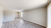 This 520 square foot apartment in Broken Arrow, Oklahoma, offers a practical and contemporary living space. The single-story layout comprises one bedroom, one bathroom, a living room, and a hallway with a closet. The living area is the focal point, featuring sleek wood-look flooring and ample natural light from a sliding glass door and windows. The 130 square foot bedroom is carpeted for comfort and includes a window for added brightness. The bathroom is efficiently designed with a single vanity, toilet, and bathtub/shower combination. White cabinetry and fixtures contribute to a clean, modern aesthetic throughout. The apartment's open concept and neutral color palette create a sense of spaciousness despite its compact size. Ceiling fans and textured ceilings add visual interest and practical comfort. This property at 709 W Houston St combines functionality with modern design elements, making it an ideal space for single occupancy or a cozy home for a couple.