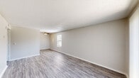 This 520 square foot apartment in Broken Arrow, Oklahoma, offers a practical and contemporary living space. The single-story layout comprises one bedroom, one bathroom, a living room, and a hallway with a closet. The living area is the focal point, featuring sleek wood-look flooring and ample natural light from a sliding glass door and windows. The 130 square foot bedroom is carpeted for comfort and includes a window for added brightness. The bathroom is efficiently designed with a single vanity, toilet, and bathtub/shower combination. White cabinetry and fixtures contribute to a clean, modern aesthetic throughout. The apartment's open concept and neutral color palette create a sense of spaciousness despite its compact size. Ceiling fans and textured ceilings add visual interest and practical comfort. This property at 709 W Houston St combines functionality with modern design elements, making it an ideal space for single occupancy or a cozy home for a couple.