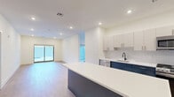 Located at 555 Northfield Avenue in West Orange, NJ, this thoughtfully designed one-bedroom, one-bathroom unit offers a clean, contemporary aesthetic across a single floor. The open-concept kitchen and living area serves as the heart of the home, featuring light wood-tone flooring, recessed lighting, and sliding glass doors that lead directly to a private patio. The kitchen is well-appointed with two-tone cabinetry — crisp white upper cabinets paired with bold navy lower cabinets — a white quartz countertop, stainless steel appliances including a gas range, microwave, dishwasher, and refrigerator, and a center island for additional prep and seating space. A textured tile backsplash adds a refined finishing touch. The spacious primary bedroom features a large window with outdoor views and generous closet space, supported by three closets throughout the unit. The bathroom is finished with large-format marble-look tile flooring, a dark vanity with gold hardware, a round mirror, and matte black accessories. Additional highlights include a versatile den, dedicated in-unit laundry, and a consistent use of neutral tones that create a bright, modern ambiance throughout.