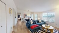 Located at 1415 NW Santa Fe Ln in Silverdale, WA, this thoughtfully designed single-floor home offers four bedrooms, two bathrooms, and a well-utilized layout that balances comfort and functionality. The open-concept living and dining area serves as the heart of the home, featuring warm hardwood-style flooring, vaulted ceilings, and abundant natural light from large windows with outdoor views. A tiled fireplace anchors the living room, adding a cozy focal point. The adjoining dining space is defined by a statement pendant light and direct access to the balcony. The kitchen features a half-wall pass-through, stainless steel appliances, and ample cabinetry, with in-unit laundry conveniently located nearby. The primary bedroom offers a private retreat with vaulted ceilings and a dedicated closet. Additional bedrooms provide flexible space, including one configured for multiple occupants with natural light from a window with outdoor views. The two bathrooms are clean and functional, each with a shower-tub combination. With six closets spread throughout, storage is plentiful. Light-toned walls and consistent flooring throughout create a cohesive, bright ambiance across every room.