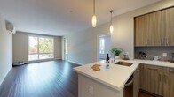 Located at 1091 W El Camino Real in Sunnyvale, California, this single-floor residence offers a thoughtfully designed layout with modern finishes and an abundance of natural light. The open-concept living and kitchen area serves as the heart of the home, showcasing rich dark hardwood flooring, neutral-toned walls, and large sliding glass doors that frame views of mature trees and the outdoors. Pendant lighting with warm tones illuminates the kitchen island, which features a white quartz countertop and an integrated sink. The kitchen is fully equipped with stainless steel appliances, including a range, microwave, and refrigerator, complemented by floor-to-ceiling wood-grain cabinetry offering generous storage. The bedrooms are carpeted for comfort and benefit from multiple windows that invite natural light and garden views. A wall-mounted mini-split HVAC unit ensures year-round climate control. The bathroom includes a floating wood-grain vanity with a white quartz countertop, a large mirror, and a full tub-shower combination with white tile surround. Throughout, the design balances a clean, contemporary aesthetic with warm, natural materials, creating a comfortable and functional living environment in the heart of Sunnyvale.