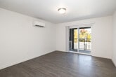 Located at 5102 W State St in Boise, Idaho, this two-bedroom, two-bathroom unit offers a well-organized single-level layout designed for comfortable everyday living. The living room is bright and open, featuring wood-style plank flooring, a textured ceiling, a ductless mini-split climate control unit, and sliding glass doors that lead to a private balcony overlooking lush outdoor scenery. The galley-style kitchen is efficiently designed with white cabinetry, white countertops, a stainless steel refrigerator, electric range, over-the-range microwave, and a dishwasher — all set on durable wood-look flooring. Both bedrooms are carpeted for comfort; the primary bedroom includes its own mini-split unit, while the second bedroom features a horizontal window that brings in natural light and outdoor views. A spacious walk-in closet with dual hanging rods and carpeted flooring provides ample storage. The bathrooms are cleanly finished in white, with one featuring a full tub-shower combination, wood-look flooring, and bright white tile surround. Throughout the unit, a neutral color palette of whites and warm grays creates a clean, cohesive ambiance.