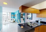 Located at 17550 N Bayshore Dr in Miami, FL, this single-floor unit is defined by a vibrant, contemporary design characterized by bold turquoise accent walls, gleaming large-format tile flooring, and an abundance of natural light throughout. The open-concept kitchen features warm wood cabinetry, dark granite countertops, stainless steel appliances including a range, built-in microwave, dishwasher, and refrigerator, along with a peninsula that connects seamlessly to the dining and living areas. The living room is bright and airy, with floor-to-ceiling sliding glass doors that open onto a private balcony offering sweeping views of Biscayne Bay and the Miami skyline. The bedrooms continue the turquoise color scheme, each featuring carpeted flooring, ample closet space, and sliding glass doors providing direct balcony access with stunning waterfront panoramas. The bathroom is cleanly finished with light tile, a tub-shower combination, and a single-sink vanity. Throughout the unit, the cohesive coastal-inspired palette and elevated vantage point create a bright, energetic ambiance reflective of Miami's dynamic waterfront lifestyle.