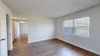 Located in the coastal community of Atlantic Beach, Florida, this single-floor residence at 900 Plaza Rd offers a clean, functional layout with consistent finishes throughout. The living areas feature durable wood-look flooring in a warm tone, complemented by light gray walls, crisp white baseboards, and textured ceilings that add subtle depth to each room. Natural light filters in through multiple windows fitted with horizontal blinds, creating a bright and airy atmosphere across the main living spaces.

The kitchen is well-appointed with rich, dark wood cabinetry, granite-style countertops, and a full suite of stainless steel appliances including a range, over-the-range microwave, and sink. A stacked washer and dryer unit is conveniently tucked within the kitchen area, alongside a louvered-door storage closet for added utility.

The bedrooms are carpeted in a neutral gray tone, providing a comfortable and quiet retreat. Each bedroom features large windows that invite natural light, and at least one includes an open closet with a built-in hanging rod. The bathroom is finished with a dark wood vanity, granite-look countertop, a single undermount sink, and wood-look tile flooring, maintaining a cohesive aesthetic with the rest of the home. The overall design is straightforward, well-maintained, and move-in ready.