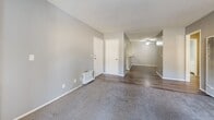 Located at 1901 E Amar Rd in West Covina, CA, this single-story residence offers three bedrooms and two bathrooms within a thoughtfully arranged floor plan. The living room serves as the heart of the home, featuring plush carpeting, a fireplace, and a sliding glass door that opens to a private balcony with outdoor views — bringing in abundant natural light. The kitchen is well-appointed with white cabinetry, granite-style countertops, stainless steel appliances including a gas range and microwave, and light wood-style flooring. A skylight overhead adds a bright, airy quality to the cooking space, which also features a peninsula counter for added functionality. The three bedrooms are carpeted in neutral tones and painted in soft gray, with vertical blinds on the windows. The spacious primary bedroom includes a closet with sliding doors. Both bathrooms feature light wood-style flooring and clean white fixtures; one includes a tub-shower combination with a vanity, while the other offers a compact shower layout. A connecting hallway ties the layout together efficiently. The consistent neutral gray palette and modern finishes throughout give the space a clean, cohesive aesthetic.