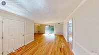 Located at 2723 Campus Walk Ave in Durham, NC, this single-story home offers four bedrooms, two bathrooms, and a thoughtfully laid-out floor plan. Warm hardwood flooring flows throughout the living areas and all four bedrooms, creating a cohesive and inviting atmosphere. The open living room is a standout space, featuring crown molding, chair rail detailing, a textured ceiling, and a sliding glass door that fills the room with natural light and provides access to the outdoors. The kitchen is functionally designed in a galley style, outfitted with white cabinetry, granite-toned countertops, a double stainless steel sink, and white appliances, all set atop durable tile flooring. Each of the four bedrooms is well-proportioned, with large windows that invite natural light and provide outdoor views; each room also benefits from dedicated closet space. The two full bathrooms are clean and bright, each featuring a tub-shower combination with built-in shelving, a vanity with storage, and tile flooring. With four closets throughout the home, storage is plentiful. The layout is efficient and functional, making this Durham residence a practical and comfortable home.