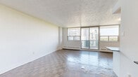 Located at 1360 Danforth Rd in Toronto's Scarborough community, this well-appointed 2-bedroom, 1-bathroom unit offers a comfortable and functional layout across a single floor. Parquet hardwood flooring flows throughout the living spaces, adding warmth and character to the interior.

The open-concept living room is generously sized, bathed in natural light through large floor-to-ceiling sliding glass doors that lead to a balcony with scenic views of the surrounding greenery and cityscape. The renovated kitchen is a standout feature, boasting crisp white shaker cabinetry, a classic subway tile backsplash, dark countertops, and a full suite of stainless steel appliances, including a refrigerator, stove, microwave, and dishwasher. Light tile flooring completes the clean, modern aesthetic.

The spacious primary bedroom offers ample natural light from a wide window and features two mirrored sliding closets, providing generous storage. The second bedroom is bright and versatile, with its own window framing neighbourhood views. The bathroom is finished with white subway tile surrounding a full soaking tub and shower, complemented by stone-look floor tiles for a clean, timeless look.