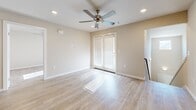Located in Searcy, Arkansas, this single-floor unit offers a clean, modern layout designed for comfortable everyday living. The kitchen serves as a functional centerpiece, featuring rich dark cabinetry, light granite countertops, a central island with seating, and black appliances including a refrigerator, range, microwave, and dishwasher. Light wood-style flooring runs throughout the main living and kitchen areas, lending warmth and continuity to the space.

The living area is generously proportioned, with recessed lighting, a ceiling fan, and an open flow that connects seamlessly to the kitchen. Bedrooms are carpeted for comfort, each equipped with ceiling fans and window blinds that allow natural light to filter in softly. A spacious walk-in closet with built-in shelving and hanging rods provides ample storage.

The bathrooms are finished with light wood-style flooring, dark vanities with granite countertops, and full tub-shower combinations. Clean, neutral wall tones are consistent throughout the unit, creating a calm and cohesive aesthetic.

A private balcony extends the living space outdoors, offering open views of the surrounding community and ample natural light. Staircase access is visible in the floor plan, indicating convenient entry. Overall, the space presents a well-maintained, move-in-ready environment suited for a range of lifestyles.