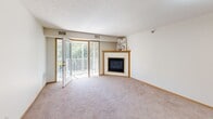 Located at 1045 Yellow Brick Rd in Chaska, Minnesota, this single-floor residence offers a well-organized layout with a comfortable and functional design throughout. The open living area is a standout feature, showcasing a corner fireplace with a wood-trimmed surround and direct access to a private deck through sliding glass doors, flooding the space with natural light and offering pleasant outdoor views. Plush carpeting runs throughout the living areas and bedrooms, complemented by warm wood-toned baseboards and trim.

The galley-style kitchen is efficiently designed with ample honey-toned cabinetry, durable wood-look flooring, a double-basin sink, and black appliances including a refrigerator, range, microwave, and dishwasher. A breakfast bar with seating opens toward the living area, creating a connected, social atmosphere.

The bedrooms are generously sized, each featuring plush carpet, natural light from windows with blinds, ceiling fans with light fixtures, and textured ceilings. At least one bedroom includes a walk-in closet with built-in shelving for added storage.

Two full bathrooms are finished with white tile flooring, oak cabinetry, wide vanity mirrors, and neutral wall tones, offering a clean and practical aesthetic throughout.