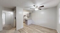 This well-organized 2-bedroom, 2-bathroom single-floor home on Edgemere Blvd in El Paso, Texas offers a practical and comfortable layout. The living room greets you at the entrance with light-toned carpet, two windows that invite natural light, and a ceiling fan overhead. It flows seamlessly into the dining area and kitchen, where light wood-style flooring continues throughout. The kitchen is equipped with grey cabinetry, granite-style countertops, a double-basin sink, and black appliances including a refrigerator, dishwasher, and range. A peninsula counter connects the kitchen to the dining space, enhancing the open feel. Each bedroom features carpet flooring and ceiling fans, with the primary bedroom offering dual closets for generous storage. The second bedroom also includes a ceiling fan and closet access. Both bathrooms are finished with clean white tile, including a tub-shower combination with grab bars in one bath. Additional storage is provided through three closets, including a shelved unit ideal for pantry or linen use. Textured ceilings are consistent throughout the home, adding a classic touch. The overall aesthetic is neutral and move-in ready, with a clean, understated palette throughout.
