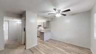 This well-organized 2-bedroom, 2-bathroom single-floor home on Edgemere Blvd in El Paso, Texas offers a practical and comfortable layout. The living room greets you at the entrance with light-toned carpet, two windows that invite natural light, and a ceiling fan overhead. It flows seamlessly into the dining area and kitchen, where light wood-style flooring continues throughout. The kitchen is equipped with grey cabinetry, granite-style countertops, a double-basin sink, and black appliances including a refrigerator, dishwasher, and range. A peninsula counter connects the kitchen to the dining space, enhancing the open feel. Each bedroom features carpet flooring and ceiling fans, with the primary bedroom offering dual closets for generous storage. The second bedroom also includes a ceiling fan and closet access. Both bathrooms are finished with clean white tile, including a tub-shower combination with grab bars in one bath. Additional storage is provided through three closets, including a shelved unit ideal for pantry or linen use. Textured ceilings are consistent throughout the home, adding a classic touch. The overall aesthetic is neutral and move-in ready, with a clean, understated palette throughout.