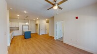 This single-story residence in Slidell, Louisiana offers a comfortable and modern living experience with two bedrooms and two full bathrooms. The open-concept main living area seamlessly connects the kitchen, dining, and living spaces, all finished with warm wood-look luxury vinyl plank flooring. The kitchen is a standout feature, boasting crisp white shaker cabinetry, granite countertops, a central island with pendant lighting overhead, and white appliances including a refrigerator, range, and built-in microwave. Natural light fills the living area through a large window, complemented by a ceiling fan that enhances airflow and comfort. The bedrooms are carpeted for warmth and comfort, each with a ceiling fan and window offering outdoor views. The primary bathroom features a dual-sink vanity with granite countertops, white cabinetry, and direct access to a spacious walk-in closet with wire shelving. The second bathroom is equally well-finished. Throughout the unit, neutral tones and clean lines create a bright, cohesive ambiance. Multiple closets and storage spaces add practical functionality to this thoughtfully designed residence.