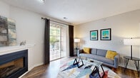 This single-floor residence offers a thoughtfully designed layout that balances comfort and functionality throughout. The living room serves as the heart of the home, featuring warm hardwood-style flooring, a sliding glass door that opens to a private outdoor balcony, and an abundance of natural light framed by floor-length drapes. A compact dining nook adjacent to the living area provides an intimate setting for meals, accented by decorative wall art. The kitchen is equipped with stainless steel appliances, including a refrigerator, range, and over-the-range microwave, all complemented by crisp white cabinetry and light countertops. Hardwood-style flooring continues through the kitchen, enhancing its clean and modern aesthetic. The bedroom is a serene retreat with plush carpeting, a window that invites soft natural light, and access to a generously sized walk-in closet outfitted with wire shelving and hanging rods for ample storage. The bathroom features a wide vanity with under-sink cabinetry, a large mirror, and wood-look tile flooring, with a separate water closet for added privacy. Rounding out the unit, a dedicated laundry room houses a full-sized washer and dryer along with overhead shelving, providing practical everyday convenience.