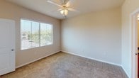 Located at 30951 Hanover Ln in Menifee, California, this single-story home offers a practical and well-organized layout designed for comfortable everyday living. The open-concept living area is generously sized, featuring plush carpeting, crown molding, and a ceiling fan with integrated lighting. Natural light filters in through a sliding glass door fitted with vertical blinds, while a peninsula counter visually connects the living space to the kitchen.

The kitchen is equipped with warm wood cabinetry, dark granite-style countertops, and black appliances including a refrigerator, electric range, and over-the-range microwave. Light hardwood-style flooring runs throughout the kitchen and entry areas, providing a clean contrast to the carpeted rooms.

The bedrooms are carpeted and well-proportioned, each featuring ceiling fans, windows with blinds that bring in natural light, and access to closet space. The primary bedroom includes a walk-in closet for added storage.

The bathroom is appointed with a single-sink vanity featuring dark countertops and wood cabinetry, a full tub-shower combination with tiled surround, and hardwood-style flooring. The neutral, warm color palette throughout the home creates a cohesive and inviting atmosphere.
