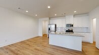 Located at 2146 Miller Chapel Rd SE in Conyers, GA, this well-appointed two-story home offers 3 bedrooms, 4 bathrooms, and a thoughtfully designed layout spread across two floors. The main level features an open-concept kitchen and living area bathed in recessed lighting, with warm hardwood-style flooring that carries throughout the home. The kitchen is a standout, showcasing white shaker cabinetry, granite countertops, a tile backsplash, and a full suite of stainless steel appliances including a refrigerator, range, microwave, and dishwasher. A generous kitchen island provides additional prep and dining space.

The upper floor houses all three bedrooms, including a primary suite with a tray ceiling, ceiling fan, and a private en-suite bathroom featuring granite vanity countertops. Additional bedrooms are bright and airy with clean white walls and hardwood-style flooring. Two closets, including a walk-in with wire shelving, offer ample storage. The four bathrooms maintain a consistent, clean aesthetic with granite finishes. The attached garage provides secure parking and utility access. Clean lines, neutral tones, and modern finishes give this home a fresh, move-in-ready feel.