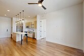Located at 2825 W 11th St in Houston, TX, this thoughtfully designed one-bedroom, one-bathroom residence offers a clean, modern aesthetic throughout its efficiently utilized single-floor layout. Warm-toned hardwood flooring flows seamlessly across the open-concept living, dining, and kitchen areas, creating a cohesive and inviting atmosphere.

The kitchen is a standout feature, outfitted with light wood cabinetry, a white quartz waterfall island with dramatic pendant lighting, stainless steel appliances including a French door refrigerator, range, microwave, and dishwasher, plus a built-in wine rack and dedicated desk or storage nook. Recessed lighting and a ceiling fan enhance both functionality and comfort.

The living area benefits from natural light and opens toward French doors leading to a private balcony, while the bedroom features large windows with outdoor views and its own ceiling fan. Two closets — including a well-organized walk-in — provide ample storage.

The bathroom impresses with full marble-look tile on both the floors and tub surround, a dual-sink vanity with light wood cabinetry, black fixtures, and a large mirror, delivering a spa-like finish. This residence combines contemporary design with practical living in a well-appointed Houston location.