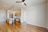 Located at 2825 W 11th St in Houston, TX, this thoughtfully designed one-bedroom, one-bathroom residence offers a clean, modern aesthetic throughout its efficiently utilized single-floor layout. Warm-toned hardwood flooring flows seamlessly across the open-concept living, dining, and kitchen areas, creating a cohesive and inviting atmosphere.

The kitchen is a standout feature, outfitted with light wood cabinetry, a white quartz waterfall island with dramatic pendant lighting, stainless steel appliances including a French door refrigerator, range, microwave, and dishwasher, plus a built-in wine rack and dedicated desk or storage nook. Recessed lighting and a ceiling fan enhance both functionality and comfort.

The living area benefits from natural light and opens toward French doors leading to a private balcony, while the bedroom features large windows with outdoor views and its own ceiling fan. Two closets — including a well-organized walk-in — provide ample storage.

The bathroom impresses with full marble-look tile on both the floors and tub surround, a dual-sink vanity with light wood cabinetry, black fixtures, and a large mirror, delivering a spa-like finish. This residence combines contemporary design with practical living in a well-appointed Houston location.