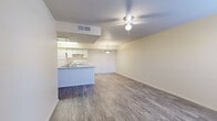 This single-story, 2-bedroom, 2-bathroom residence offers a functional and comfortable layout across a thoughtfully designed floor plan. The open-concept living and kitchen area serves as the heart of the home, featuring durable wood-look plank flooring, neutral-toned walls, and a ceiling fan that enhances air circulation throughout. The kitchen is equipped with white cabinetry, a white electric range, a refrigerator, and a peninsula with a light-toned countertop and double sink — ideal for both cooking and casual dining. A pendant light fixture above the peninsula adds a decorative touch.

The primary bedroom is a generously sized retreat with soft carpeting, a ceiling fan, a closet, and natural light from a window with blinds. The second bedroom also features plush carpeting, a window with natural light, and a ceiling fan. Both bathrooms are finished with wood-look flooring, white vanities with mirrors, and tub-shower combinations with white tile surrounds.

Additional highlights include a dedicated laundry area, an accessible electrical panel, and consistent neutral finishes throughout. The overall ambiance is clean, bright, and move-in ready, offering a practical and comfortable living environment.