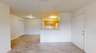 Located at 12450 Biscayne Blvd in Jacksonville, FL, this 2-bedroom, 2-bathroom single-story residence offers a practical and well-organized floor plan. The living room serves as the heart of the home, featuring light wood-style laminate flooring, a ceiling fan, and a large window fitted with vertical blinds that fills the space with natural light and offers views of the surrounding greenery. Adjacent to the living area, the kitchen is designed with a peninsula pass-through counter, warm honey-toned wood cabinetry, white appliances including a range and refrigerator, and matching light flooring — creating a cohesive and functional cooking space. Both bedrooms are carpeted and equipped with ceiling fans and windows that bring in natural light. The spacious primary bedroom includes a generous walk-in closet outfitted with wire shelving, providing ample storage. The bathrooms feature full tub-shower combinations with clean white tile surrounds. Two closets throughout the home ensure practical storage solutions. The unit maintains a neutral, light color palette across all rooms — cream walls paired with light flooring — lending a bright, clean, and move-in-ready ambiance throughout.