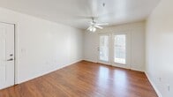 Located at 171 Cory Dr in Lenoir City, Tennessee, this single-floor, 2-bedroom, 2-bathroom residence offers a practical and comfortable layout. The living room is a bright, open space featuring warm hardwood-style flooring, a ceiling fan with light fixture, and French doors that provide direct access to a private outdoor balcony, allowing natural light to flow freely into the room. The kitchen is well-equipped with warm wood cabinetry, dark speckled countertops, a double basin sink, a white electric range, dishwasher, and refrigerator. Tile flooring runs throughout the kitchen, which opens toward the living area for a connected feel. The primary bedroom is generously sized, showcasing hardwood-style flooring, a ceiling fan, and two windows that bring in ample natural light. It includes a walk-in closet outfitted with wire shelving and hanging rods for organized storage. The second bedroom also features hardwood-style flooring and its own closet. Both bathrooms are finished with tile flooring, wood vanity cabinetry, dark countertops, and full tub-shower combinations. The consistent use of warm tones and practical finishes throughout creates a cohesive and functional living environment well-suited for everyday comfort.