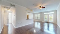 Located at 5616 Jackson St in Houston's 77004 zip code, this single-floor residence offers a thoughtfully designed layout with a blend of comfort and modern finishes throughout. The open-concept living and dining area is a standout feature, showcasing richly stained hardwood floors that reflect natural light pouring in through large windows and French doors. Crown molding and a ceiling fan with light kit add a polished touch to the living space, which opens directly onto a private balcony with views of mature trees. The kitchen is well-appointed with white shaker-style cabinetry, dark granite countertops, stainless steel appliances including a refrigerator, range, microwave, and dishwasher, and matching hardwood flooring. A pass-through counter connects the kitchen to the main living area. The bedrooms are carpeted for comfort and receive natural light from windows overlooking greenery. The primary bedroom includes a ceiling fan, access to a spacious walk-in closet with built-in wire shelving, and an en-suite bathroom featuring dual sinks set in granite countertops, white cabinetry, and a tub-shower combination. An additional full bathroom mirrors similar finishes, maintaining consistency throughout the home.