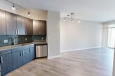 Unit 640 at 3514 Columbia Pike offers a thoughtfully designed one-bedroom, one-bathroom layout in Arlington, VA. The open-concept living, dining, and kitchen area is anchored by light-toned hardwood-style flooring and neutral walls, creating a bright and cohesive feel throughout. The kitchen is a standout feature, equipped with dark two-tone cabinetry, granite countertops, a mosaic tile backsplash, and a full suite of stainless steel appliances including a refrigerator with bottom freezer, electric range, microwave, and dishwasher. Track lighting overhead adds a modern touch. The spacious bedroom is finished with plush carpet, soft neutral walls, and a window allowing natural light. A dedicated closet provides ample storage. The bathroom features clean white subway tile in the tub-shower combo with a bold black accent band, complemented by granite countertops and contemporary cabinetry. Additional conveniences include an in-unit laundry area and a private balcony. The unit's clean, modern aesthetic and efficient floor plan make it a well-appointed residence in the Columbia Pike corridor of Arlington.