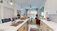 Located on Erwin Road in Durham, NC, this single-floor residence presents a thoughtfully designed open-concept layout that seamlessly connects the kitchen and living areas. The kitchen is a standout feature, equipped with stainless steel appliances including a French door refrigerator, electric range, and microwave. Two-tone cabinetry pairs white upper cabinets with natural wood-toned lower cabinets, complemented by a white subway tile backsplash and light quartz countertops. A central island with seating provides additional workspace and casual dining, illuminated by globe pendant lights overhead.

The living area flows naturally from the kitchen, highlighted by a ceiling fan, light wood-style flooring, and a large window that admits generous natural light and outdoor views. The space accommodates comfortable seating arrangements with room for a defined dining area as well.

The bedrooms offer a calm retreat, featuring plush carpeting, neutral walls, and windows dressed with linen-toned drapes. The bathroom is finished in a clean, contemporary style with wood-toned vanity cabinetry, black hardware accents, light wood-style flooring, and a tiled walk-in shower. Throughout, the unit maintains a cohesive, modern aesthetic with consistent use of light tones and black hardware details.