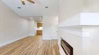 Located at 703 S Hutchinson Ave in Adel, Georgia, this single-story, 2-bedroom, 2-bathroom home offers a thoughtfully designed layout with consistent, modern finishes throughout. Warm wood-look flooring flows seamlessly across the main living areas and bedrooms, complemented by neutral, light-toned walls and crisp white trim that give the home a clean, inviting feel.

The living room serves as the heart of the home, featuring vaulted ceilings, a ceiling fan, a sleek built-in fireplace with a white mantel surround, and a window that brings in natural light and outdoor views. The kitchen is well-equipped with light wood shaker-style cabinetry, white countertops, a double-basin sink, and a full suite of stainless steel appliances including a refrigerator, range, microwave, and dishwasher.

Both bedrooms are comfortably sized, each with ceiling fans and dedicated closets. The primary bedroom is notably spacious and includes direct access to its own bathroom and a closet. Each bathroom features a tub-shower combo, with one including a warm wood vanity with an integrated sink, a large mirror, and elegant marble-look tile flooring. The second bathroom mirrors this clean aesthetic with the same tile flooring and bright, white fixtures throughout.
