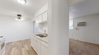 Located at 620 Gorman St in Shakopee, Minnesota, this single-floor, 2-bedroom, 1-bathroom residence offers a practical and well-organized layout. The galley-style kitchen is a standout feature, showcasing white cabinetry, granite-look countertops, a double sink, and white appliances including a gas range and refrigerator. Warm wood-look flooring runs throughout the kitchen, which connects seamlessly to the hallway and living areas. Both bedrooms are carpeted and bright, benefiting from natural light through large windows dressed with vertical blinds. Each bedroom includes generous louvered bi-fold closets offering ample storage. Baseboard heating is present throughout, and one bedroom also features a wall-mounted air conditioning unit. The bathroom is clean and classic, with fully tiled walls surrounding a soaking bathtub. A connecting hallway ties the rooms together efficiently. The overall interior palette is neutral and bright, with white walls and light-toned finishes throughout, creating a clean and easy-to-personalize living environment. The layout maximizes the use of the available floor space, making the residence comfortable and livable.