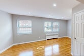 Located at 123 Davey Street in Bloomfield, NJ, this single-floor home offers three bedrooms, one bathroom, and a kitchen, all connected by two hallways. The layout is practical and well-organized, making efficient use of its footprint.

Warm-toned hardwood flooring runs throughout the living spaces and bedrooms, complementing the neutral gray walls and crisp white trim. The primary bedroom is generously sized and features recessed lighting, a dedicated closet, and a six-panel white door. The additional bedrooms each offer natural light through blinds-fitted windows with views of the tree-lined neighborhood, as well as radiator heating units beneath each window.

The kitchen includes a stainless steel gas range and is equipped with a window for natural light and ventilation, along with a fire extinguisher for safety. Light-toned tile flooring distinguishes the kitchen from the rest of the unit.

The bathroom is a standout feature, finished with floor-to-ceiling marble-patterned tiles in white and gray. It includes a full soaking tub with a tiled surround and a window that allows natural light to brighten the space.

The hallways are clean and functional, connecting the rooms seamlessly. Throughout the home, consistent neutral tones, natural light, and classic hardwood floors create a cohesive and inviting atmosphere.