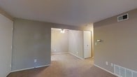Located at 5051 Open Meadow Dr in Columbus, Ohio, this single-story home offers a straightforward and functional layout designed for comfortable everyday living. The interior is finished in a consistent neutral color palette, with warm gray walls and white trim that create a clean, cohesive look throughout the space. Soft carpeting runs across the floors, adding warmth and a sense of comfort underfoot. The living area is open and spacious, flowing seamlessly into an adjoining room that benefits from a ceiling fan, providing both air circulation and a central lighting fixture. A closet with a sliding door offers convenient built-in storage. The layout is thoughtfully arranged, making efficient use of the available footprint while maintaining an airy, uncluttered feel. Smooth, well-maintained ceilings and crisp white baseboards contribute to the tidy presentation of the interior. The neutral finishes provide a versatile backdrop, making the space easy to personalize with a variety of decor styles. Overall, this single-floor home presents a practical and move-in-ready option in the Columbus, Ohio area.