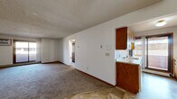 Located at 2052 15th St N in Saint Cloud, Minnesota, this single-floor, three-bedroom, one-bathroom home offers a practical and functional layout. The open living area features neutral carpet flooring that transitions to tile near the entryway, complemented by white walls, warm wood baseboards, and a textured ceiling throughout. A ceiling fan is present in the main living space, adding to the home's utility.

The kitchen is positioned adjacent to the living area and features warm-toned wood cabinetry, a countertop with sink, and a pass-through opening that connects to the main living space, enhancing the open feel of the floor plan.

The generously sized primary bedroom is notably spacious and includes a walk-in closet with dual shelving rods — offering excellent storage capacity. Additional bedrooms are carpeted and well-proportioned, each featuring ceiling light fixtures and baseboard heating. One bedroom also includes its own walk-in closet with shelving.

The full bathroom is clean and functional, equipped with a tub/shower combination, a wood-framed vanity mirror, and tile flooring. A hallway connects the bedrooms and provides additional flow throughout the home. Three closets in total ensure ample storage across the unit. Baseboard heating is present in multiple rooms, ensuring consistent warmth throughout.