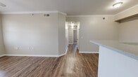 This single-story, 4-bedroom, 2-bathroom home in Denison, TX offers a practical and comfortable layout across one level. The combined kitchen and living area forms the heart of the home, featuring rich hardwood-style flooring and crown molding throughout. The living room is bright and welcoming, with natural light streaming in through a glazed entry door and adjacent window, complemented by a ceiling fan overhead. The kitchen is designed in a galley style, equipped with white cabinetry, light stone-look countertops, and white appliances including a range, microwave, and refrigerator. A peninsula counter connects the kitchen to the living area, creating an open, functional flow. The four bedrooms offer a quieter retreat, each finished with soft carpeting and neutral-toned walls. Multiple windows fitted with blinds allow for natural light and privacy control. The bedrooms vary in configuration, with some featuring hardwood-style flooring. Both bathrooms are finished cleanly in white, each offering a full tub and shower combination with tiled surrounds, a vanity with storage, and hardwood-style flooring. The home's consistent neutral palette and clean finishes throughout create a cohesive, move-in-ready atmosphere.