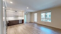 North Grove A1D (Unit 17-212) is a compact yet efficiently designed 1-bedroom, 1-bathroom apartment located in Riverside, CA 92501, totaling 290 square feet across a single floor. The open-concept living area features light wood-tone flooring, recessed lighting, and a modern kitchen equipped with stainless steel appliances — including a refrigerator, range, microwave, and dishwasher — complemented by two-tone cabinetry, a tile backsplash, and light countertops. The 120-square-foot bedroom is carpeted and bathed in natural light through large windows offering views of the surrounding community and mature trees. The bedroom connects to a walk-in closet outfitted with wire shelving along three walls, maximizing storage. The bathroom features wood-grain cabinetry with a white countertop vanity, a large mirror, tile flooring, and a shower-tub combo. A hallway connects the main living spaces. The unit also includes access to a balcony overlooking the well-maintained courtyard and parking area of this modern multi-story residential complex. Clean, neutral-toned walls and an abundance of natural light create a bright, welcoming ambiance throughout.