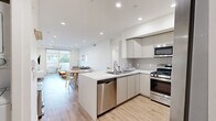 Located at 5639 Lexington Ave in the heart of Los Angeles, this modern single-story home offers four bedrooms and three bathrooms across a thoughtfully designed floor plan. The open-concept living and kitchen area serves as the centerpiece of the home, featuring light wood-look flooring, recessed lighting, and clean white walls that create a bright, airy atmosphere throughout. The kitchen is outfitted with sleek flat-front cabinetry, a classic subway tile backsplash, white quartz countertops, a central island with an undermount sink, and a full suite of stainless steel appliances including a gas range, microwave, and dishwasher. The living room opens directly to a private outdoor balcony through sliding glass doors, allowing natural light to flow in while providing a seamless indoor-outdoor connection. Bedrooms are finished in the same clean, minimalist aesthetic with light flooring and roller shade windows. The primary bedroom features a mirrored sliding-door closet with built-in shelving. All three bathrooms showcase large-format stone-look tile walls, penny-round mosaic tile flooring, and tub-shower combinations enclosed by frameless sliding glass doors, conveying a polished, contemporary feel throughout.