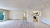 Located in Puyallup, WA, this single-floor home offers four bedrooms and two bathrooms within a thoughtfully designed layout. The open living room is a welcoming centerpiece, featuring a tile-surround fireplace, plush carpet, and a sliding glass door that opens to an outdoor balcony, allowing natural light to fill the space. The galley-style kitchen is equipped with stainless steel appliances—including a refrigerator, electric range, and microwave—complemented by light wood cabinetry, white countertops, and easy-care hardwood-style flooring. A pantry closet provides additional storage just off the kitchen. The living and kitchen areas flow seamlessly, connected by an open pass-through that enhances the sense of openness. Each of the four bedrooms features soft carpeting and windows that bring in natural light, with the bedrooms offering a calm, neutral palette. A dedicated closet provides well-organized wire-rack shelving for storage. The two bathrooms are finished with light wood vanities, white countertops, large mirrors, and one includes a full soaking tub with shower. A central hallway connects all rooms efficiently, completing this practical and comfortable home.
