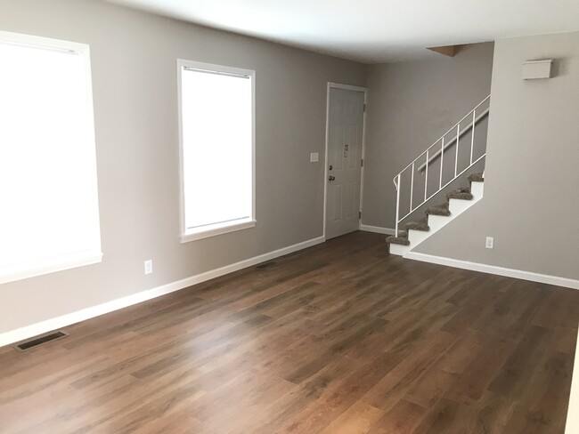Sala de estar con piso de tablones de vinilo de lujo y ventanas nuevas. - 4552 Baylor Ct