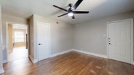 Located in Dallas, TX, this two-story, 2-bedroom, 2-bathroom home offers a well-organized layout spread across two floors. The main level features a generously sized living room with rich dark wood-look flooring, neutral gray walls, and a large window that allows natural light to fill the space. The kitchen is a standout, showcasing powder-blue shaker-style cabinetry with matte black hardware, granite countertops, a classic white subway tile backsplash, and stainless steel appliances including a range and refrigerator. A dedicated laundry area with a top-load washer and overhead shelving provides added convenience. The bathrooms are finished with gray vanity cabinetry, granite countertops, and framed mirrors, echoing the kitchen's cohesive aesthetic. Both bedrooms feature warm wood-look flooring, ceiling fans with integrated lighting, and windows that bring in natural light. The spacious primary bedroom offers generous room proportions and a closet. Textured ceilings and clean white baseboards throughout contribute to a consistent, move-in-ready finish. With a functional floor plan and tasteful updates, this home delivers comfortable everyday living in Dallas.