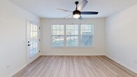Located at 100 River Chase Blvd in Beaufort, SC, this single-floor, one-bedroom, one-bathroom home offers a well-designed layout with modern finishes throughout. The open-concept kitchen and living area serves as the heart of the home, featuring light wood-style flooring, crisp white walls, and large windows fitted with blinds that fill the space with natural light. A ceiling fan with a built-in light fixture enhances comfort and airflow. The kitchen is outfitted with white shaker-style cabinetry with matte black hardware, white quartz countertops, a blue subway tile backsplash, and stainless steel appliances including a refrigerator, range, and microwave. A peninsula provides additional counter space and separates the kitchen from the living area. The bedroom offers a comfortable, carpeted retreat with a ceiling fan, a natural light-filled window, and access to a dedicated closet. The bathroom is clean and contemporary, featuring a white vanity with quartz countertop, matte black fixtures, a framed mirror, and a tub-shower combination. Additional spaces include a pantry, laundry area, utility room, and extra closet storage, providing practical functionality throughout this efficiently designed Beaufort home.