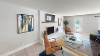 Located at 300 Pelham Rd in Greenville, SC, this single-floor space offers a thoughtfully designed layout that balances comfort, function, and style. Light hardwood-style flooring flows throughout, tying together each distinct area with a clean, cohesive aesthetic.

The kitchen is outfitted with bright white cabinetry, dark stone countertops, and stainless steel appliances, including a full-size refrigerator and microwave. A peninsula with seating for multiple guests provides a casual dining and gathering spot, making the kitchen both practical and social.

The living area centers around a white-painted brick fireplace with a warm wood mantel, creating an inviting focal point. Natural light filters in through a glass door leading to the exterior, while contemporary artwork and plush seating contribute to a relaxed yet stylish atmosphere.

A spacious game and recreation area extends the layout further, featuring a foosball table, a café-style dining set, and open shelving with decorative accents. Large windows overlook the exterior, flooding the space with natural light. This multifunctional area transitions seamlessly into adjacent rooms, offering flexibility for a variety of activities and gatherings. Overall, the space presents a modern, welcoming environment well-suited for community use.