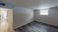 Located along East Cathedral Road in Philadelphia, PA, this single-floor unit offers a thoughtfully updated interior with a clean, modern aesthetic. The open layout is anchored by dark hardwood-style plank flooring that runs throughout the main living areas and bedrooms, providing a cohesive and contemporary look.

The kitchen is a standout feature, outfitted with white shaker-style cabinetry, a classic white subway tile backsplash, dark granite countertops, and stainless steel appliances including a gas range, microwave, and dishwasher. A peninsula counter adds additional prep and dining space, while light hardwood-style flooring in this area offers a subtle contrast to the rest of the unit.

The living area is bright and open, with multiple windows fitted with blinds that allow for natural light and a floor-mounted vent for climate control. The bedrooms mirror this understated design — each featuring gray-toned walls, dark plank flooring, and windows that bring in outside light.

The bathroom maintains the unit's clean, neutral palette with white subway tile walls, a white vanity with an integrated sink, a framed mirror, and a combination tub and shower. A brushed nickel light fixture overhead completes the polished look. Overall, the space presents a well-maintained, move-in-ready environment with consistent modern finishes throughout.