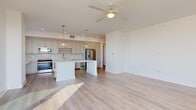 Located at 468 Quay Commons in the heart of Sarasota, FL 34236, this well-appointed single-floor residence offers four bedrooms and two bathrooms with a clean, modern aesthetic throughout. Light-toned hardwood-style flooring flows continuously across the entire home, complementing the crisp white walls and creating a bright, cohesive feel.

The open-concept kitchen and living area serves as the centerpiece of the home. The kitchen features soft gray shaker-style cabinetry, a white quartz countertop island, a tile backsplash, stainless steel appliances including a refrigerator, range, and microwave, plus a built-in wine cooler. Pendant globe lights hang above the island, and a ceiling fan with light anchors the adjacent living space.

The four bedrooms are generously proportioned, with the primary bedroom offering direct access to a private balcony with outdoor views. Bedrooms feature ceiling fans and ample natural light from large windows. Two walk-in closets with wire shelving systems provide practical storage solutions.

The bathrooms are finished with neutral tile flooring, white quartz vanities, and matte black hardware and fixtures, adding a modern contrast. One bathroom includes a tiled tub-shower combination. A connecting hallway links all rooms efficiently, maintaining a functional and comfortable flow throughout this Sarasota residence.