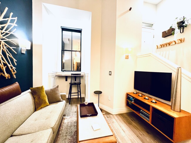 Living room with mounted tv and entertainment center. - 1431 11th St NW