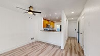 Located at 1415 W Casino Rd in Everett, WA, this two-story, 2-bedroom, 3-bathroom home is thoughtfully laid out across two well-proportioned floors. The main level features a bright, open living area with light-toned luxury vinyl plank flooring that flows throughout, bathed in natural light from large French doors that lead to an outdoor space. A ceiling fan adds both function and character to the living room. The kitchen is positioned adjacent to the living area and features warm wood cabinetry, dark granite countertops, stainless steel appliances including a microwave and range, and a peninsula that creates a natural division between the cooking and living spaces. A window above the counter brings in additional natural light. Three bathrooms serve the home, including one featuring a soaking tub and shower combo with brushed gold fixtures and clean white surround. Upstairs, the two bedrooms are carpeted for comfort and warmth, with vaulted ceilings adding an airy sense of volume. The spacious primary bedroom includes a window with outdoor views, while the second bedroom features a high transom-style window. The overall aesthetic is clean and bright, with white walls, recessed lighting, and consistent finishes throughout.